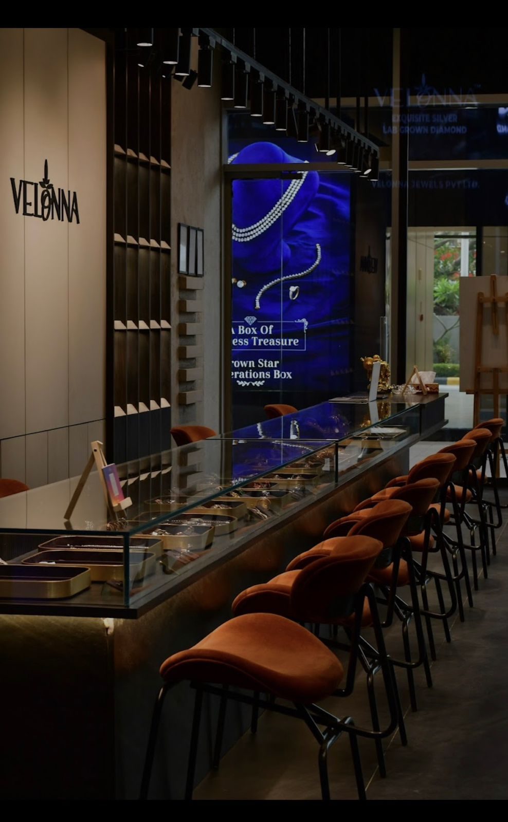 Inside the Velonna store: the sign, the screen, the long counter with orange stools